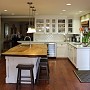 Los Altos Remodel - New kitchen, with dining & living room beyond. The glow of natural wood compliments the soft olive green walls. Brilliant white subway tiles and Shaker-style cabinetry show crisply against this organic-hued, soothing backdrop.